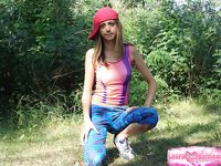 Naked teen debuts solo by pine trees in pulled-down beanie.