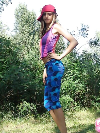 Naked teen debuts solo by pine trees in pulled-down beanie.