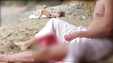 A petite girl jerks off a kinky guy at the beach