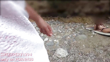 A petite girl jerks off a kinky guy at the beach