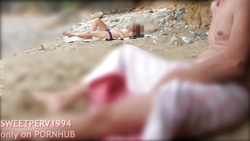 A petite girl jerks off a kinky guy at the beach